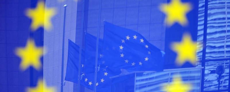 Флаги в отражении на стенде с эмблемой ЕС